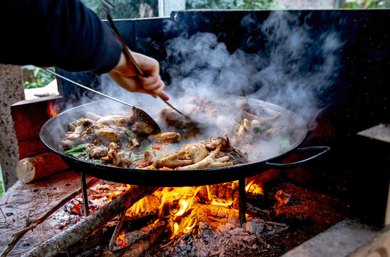 Traditional Valencian paella cooking process: preparing the tomato sofrito base &ndash; Mediterranean cuisine in Spain.
