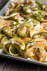 Sheet pan chicken fajitas with sliced onions, green bell peppers, and seasoned chicken arranged on a baking tray. Fresh, simple, and perfect for meal prep or easy dinner recipes.