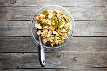 Sheet pan chicken fajitas with sliced onions, green bell peppers, and seasoned chicken arranged on a baking tray. Fresh, simple, and perfect for meal prep or easy dinner recipes.
