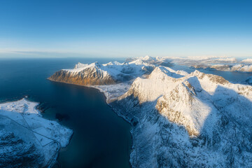 Naklejka premium Flight over the mountains. Scandinavia. Aerial view on the Lofoten Islands, Norway. Wide panoramic view of the north. Natural winter landscape from air. Photo for postcards, backgrounds, wallpapers.
