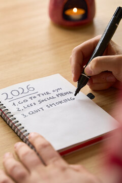 New year's resolutions. Vertical shot of hand starting 2026 goals indexed list in notebook