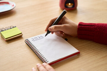 New year's resolutions. Hand writing 2026 text in notebook 