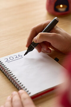 New year's resolutions. Vertical shot of hand writing 2026 text in notebook 