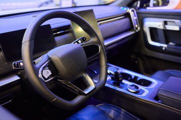 Closeup of a modern car steering wheel with control buttons for technology and convenience