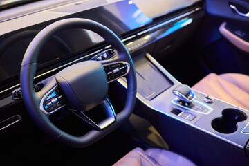 Obraz premium Closeup of a modern car steering wheel with control buttons for technology and convenience