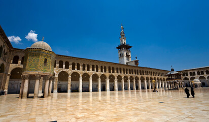 Naklejka premium The courtyard of the Umayyad Mosque in Damascus, showcasing historic Islamic architecture, marble flooring, and elegant arches. A cultural and religious landmark reflecting heritage, spirituality, an