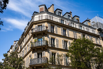 Glimpse of a typical and elegant residential building in Paris city center, France, with wrought iron railings and balconies.