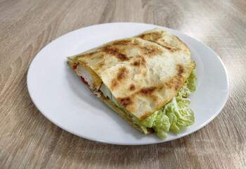 A freshly made crepe sits on a white plate