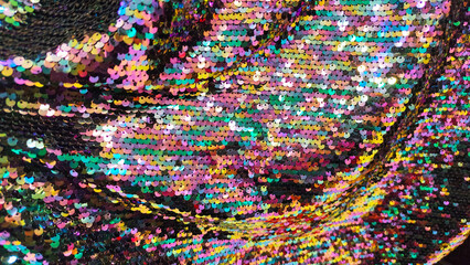 Colorful iridescent sequin fabric with shimmering reflective texture. Sparkling multicolor surface perfect for fashion backgrounds, party themes, glitter designs, and decorative visuals.