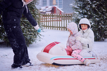 Happy Siblings Enjoying a Sled Ride Pulled by Their Big Brother on a Snowy Winter Day. Fun Family Activity in Motion.