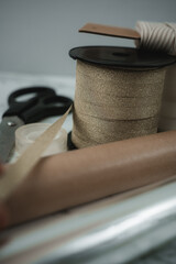 Colorful ribbon and scissors are set out, ready for wrapping gifts. The scene is cozy and festive, filled with the spirit of Christmas celebrations and thoughtful giving.