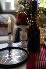 A festive bottle of champagne on the table with candles. Christmas atmosphere