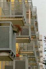 Fototapeta premium Contemporary balcony series, Urban residential facade featuring repeated balcony design, Series of modern balconies on apartment building facade showcasing geometric repetition and evening warmth