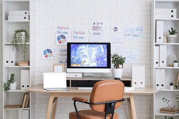 Interior of data scientist's office with workplace, diagrams and shelf units