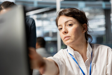 Data center engineer inspecting equipment, doing maintenance tasks, checking performance...