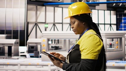 Smart manufacturing factory engineer using tablet app to calibrate high tech machinery and analyze sensor data. Engineer using digital device to troubleshoot photovoltaic assembly equipment, camera A