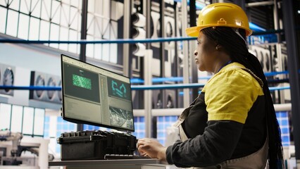 Smart solar panels factory worker typing on PC keyboard, testing automated systems, doing maintenance. Woman in industry 4.0 photovoltaics plant using computer to inspect gear and fix bugs, camera A