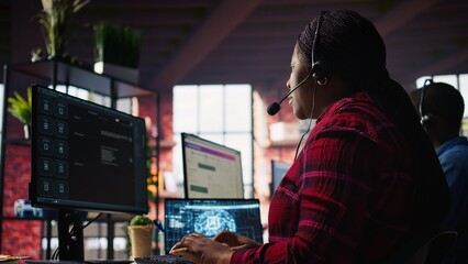 Call center worker in office using AI chatbot to provide quick replies to common customer queries. Woman doing customer service job generating automated responses to clients using AI, camera B