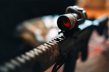 camouflaged rifle with a collimator sight