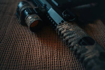 camouflaged rifle with a collimator sight