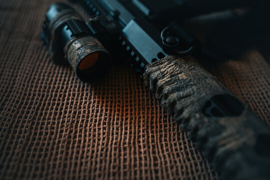 camouflaged rifle with a collimator sight