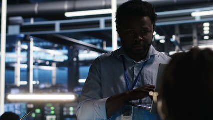 Server farm manager supervising engineer using node tree systems to categorize unstructured data. Data center supervisor overseeing IT expert using natural language processing software, camera B