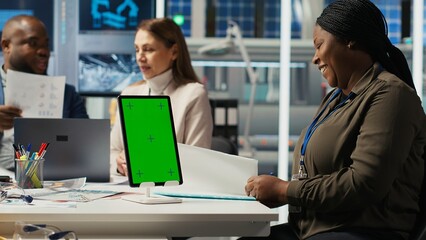 Managers in office reviewing solar technology reports on isolated screen tablet. Shareholders using chroma key device, discussing investment opportunities in green energy production, camera B