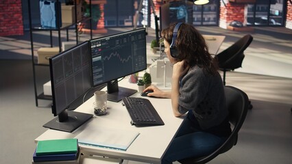 Financial investor works on PC analyzing stock market trends. The digital interface displays price fluctuations, candlestick charts. Liquidity statistics helps strategize future trading decisions