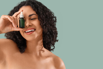 Fototapeta premium Young African-American woman with natural serum on green background, closeup
