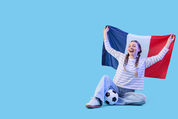 Female soccer fan with French flag and ball sitting on blue background