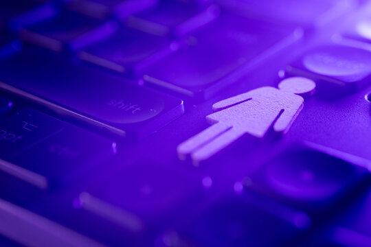 Female gender symbol on a keyboard with purple lighting, representing technology and women's empowerment in the digital age