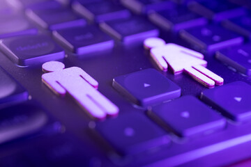 Gender symbols on a computer keyboard, representing diversity and inclusion in technology, with a vibrant purple background enhancing the visual appeal