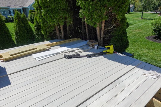 Partially constructed wooden composite backyard deck tools and planks