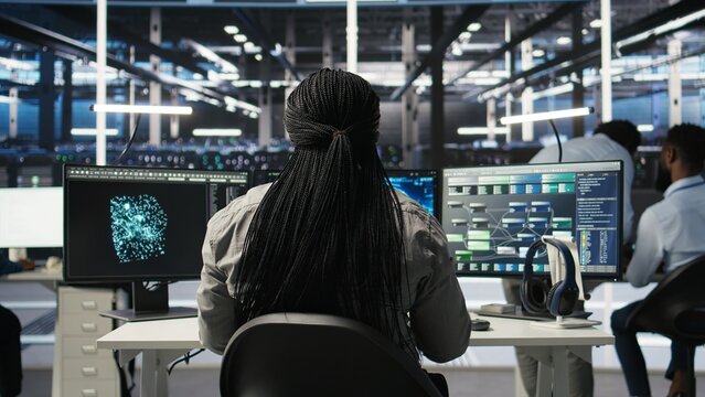 Data center programmer using artificial intelligence deep learning models to configure infrastructure. IT staff member works on AI programming language in server room, optimizing system, camera A - Powered by Adobe