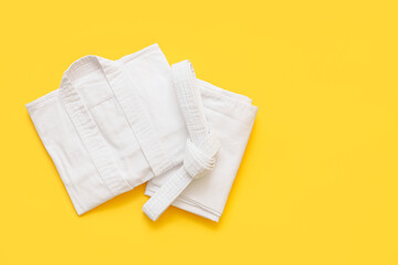 Karate uniform with belt on yellow background