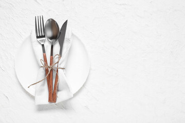 Plate with silver cutlery and napkin on white background