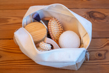 Cosmetic bag made of natural linen, with makeup brushes mocha mousse background. Concept a zero waste beauty, make-up plastic free. Eco-friendly natural cosmetic