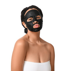 Pretty young African-American woman with activated charcoal mask on her face blowing kiss against white background