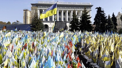 Many small blue-yellow flags with names of the dead war against russia. Memorial of the fallen soldiers, children, women in the capital of Ukraine. Concept of tragedy and misfortune. Close up