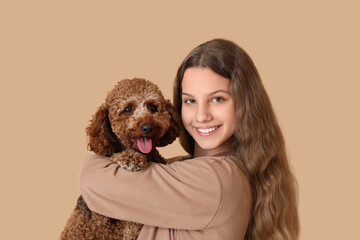 Teenage girl with Poodle dog on beige background