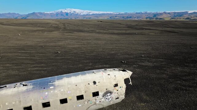 DC-3 plane wreck Iceland Solheimasandur aerial drone footage. Cinematic 4K ProRes video highlights iconic abandoned aircraft on black sand desert.