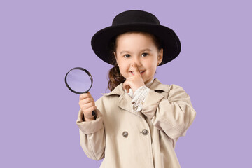 Fototapeta premium Cute little detective with magnifier showing silence gesture on lilac background