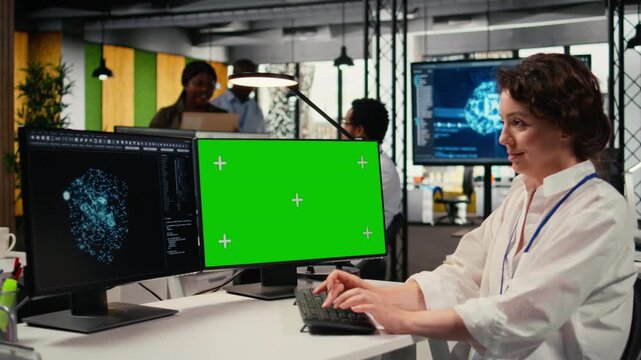 Green screen PC used by developer in office using specialized hardware to accelerate complex AI calculations. IT specialist managing deep learning training datasets with mockup computer, camera A