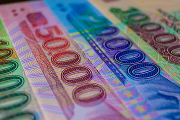 This image displays a collection of colorful Vietnamese Dong (VND) polymer banknotes, specifically the 50,000, 20,000, and 100,000 denominations, arranged in a close-up, overlapping composition. © RODWORKS