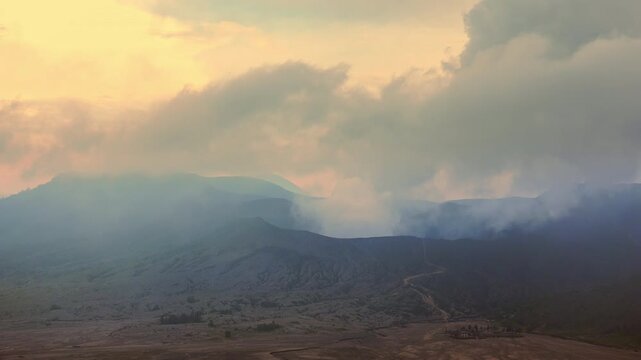 Clouds of smoke coming from crater of Mount Bromo and drifting by, Tengger Semeru national park, East Java, Indonesia. Landscape with erupting volcano in sunny day. Eruption and volcanic activity.