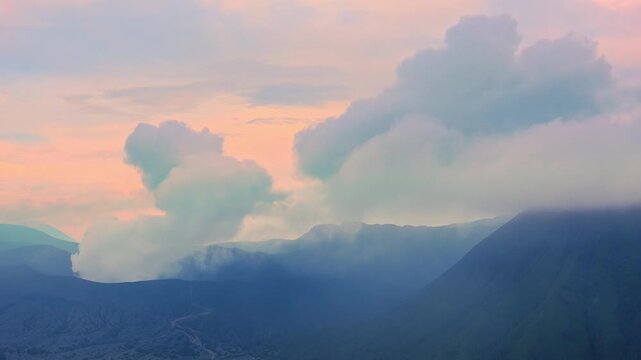 Clouds of smoke coming from crater of Mount Bromo and drifting by, Tengger Semeru national park, East Java, Indonesia. Landscape with erupting volcano in sunny day. Eruption and volcanic activity.