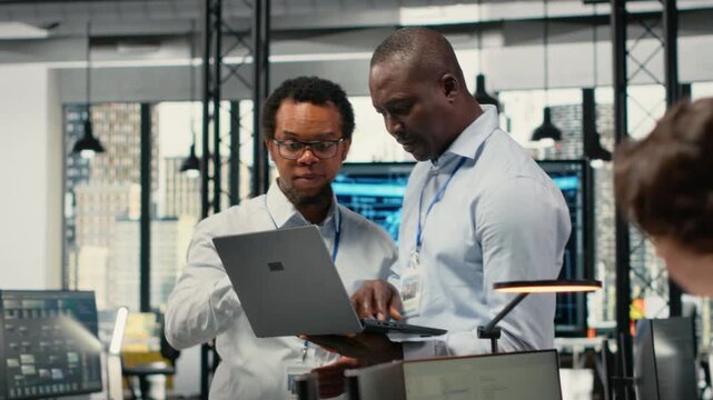 Programmers in office doing software development to launch new features, brainstorming ideas. Teamworking colleagues in startup company writing computer programs, camera B