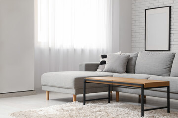 Sofa and table near window in interior of living room