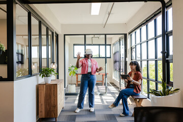 African American team demonstrating VR wearing white headset and pink top using tablet in office
