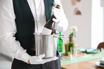 Male waiter with champagne in restaurant, closeup